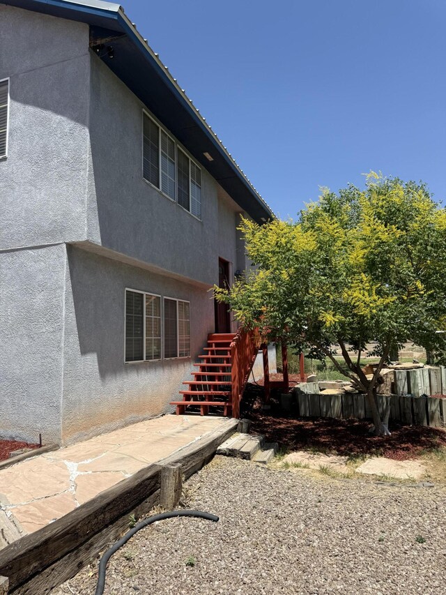 4 Los Chavez Park Rd, Belen, NM 87002 - back of house featuring stairway and stucco siding