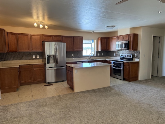 4 Los Chavez Park Rd, Belen, NM 87002 - kitchen featuring appliances with stainless steel finishes, light countertops, tasteful backsplash, a center island, and light carpet