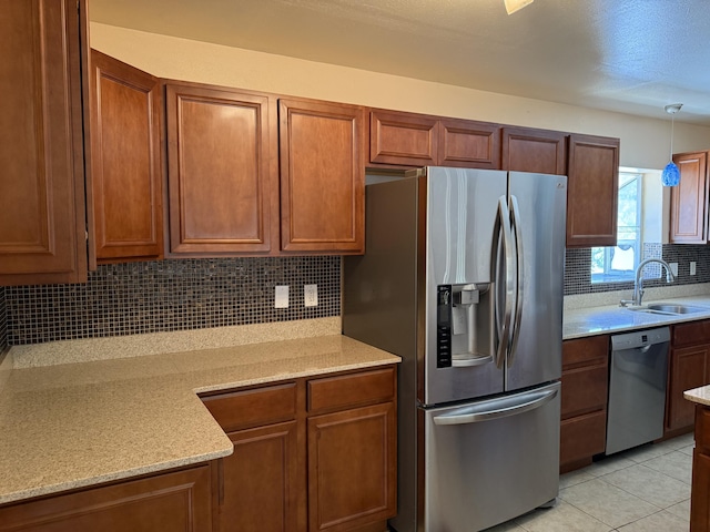 4 Los Chavez Park Rd, Belen, NM 87002 - kitchen featuring appliances with stainless steel finishes, backsplash, brown cabinetry, and pendant lighting