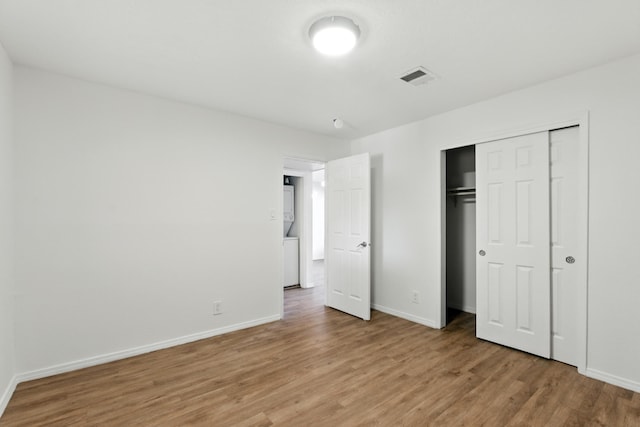 4200 Montgomery Blvd NE Unit 109, Albuquerque, NM 87109 - unfurnished bedroom with stacked washing machine and dryer, light wood-style floors, and a closet