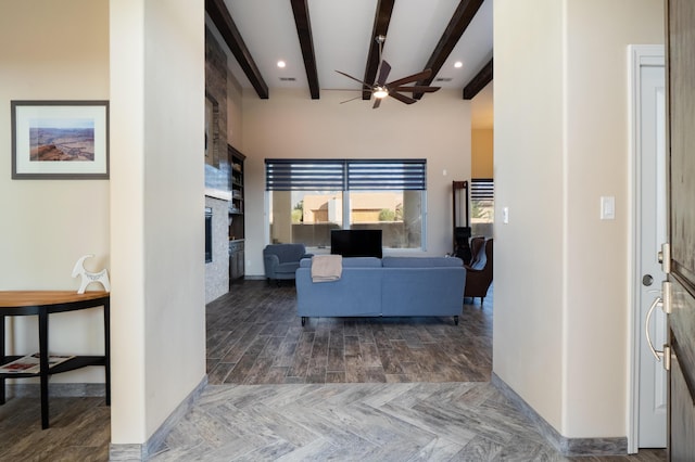 24 Norte Trl, Placitas, NM 87043 - living room with a fireplace, a ceiling fan, beam ceiling, parquet floors, and a high ceiling