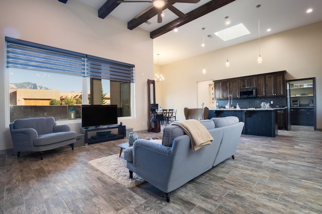 24 Norte Trl, Placitas, NM 87043 - living area featuring a high ceiling, a chandelier, beam ceiling, a skylight, and wood finished floors