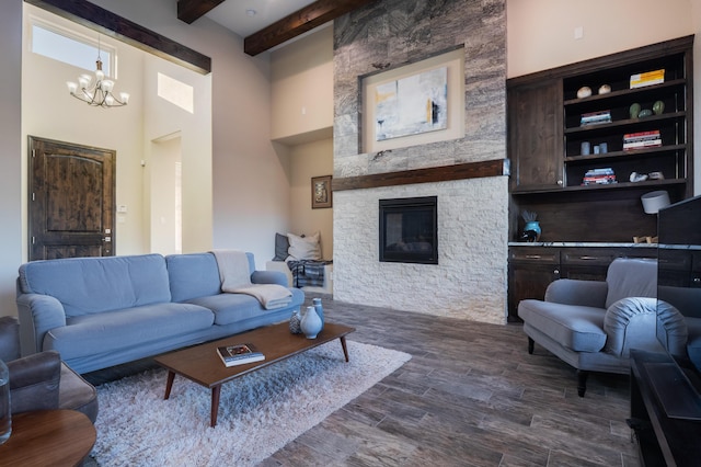24 Norte Trl, Placitas, NM 87043 - living room featuring a chandelier, beamed ceiling, dark wood-type flooring, a fireplace, and a towering ceiling