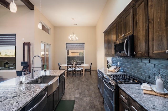 24 Norte Trl, Placitas, NM 87043 - kitchen featuring appliances with stainless steel finishes, a chandelier, decorative backsplash, dark brown cabinetry, and dark wood finished floors