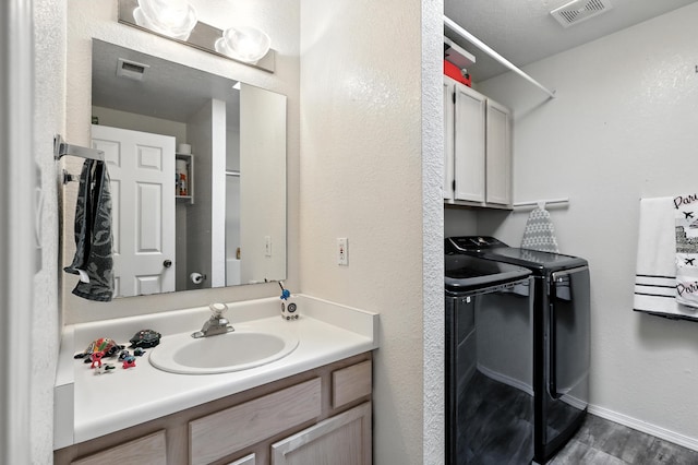 4801 Irving Blvd NW Unit 304, Albuquerque, NM 87114 - bathroom featuring independent washer and dryer, vanity, and wood finished floors