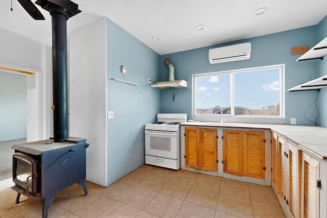 228 18th St SW, Rio Rancho, NM 87124 - kitchen featuring white gas range oven, a wall mounted air conditioner, open shelves, a wood stove, and light countertops