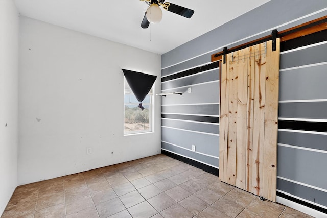 228 18th St SW, Rio Rancho, NM 87124 - unfurnished bedroom with a barn door, tile patterned floors, and ceiling fan