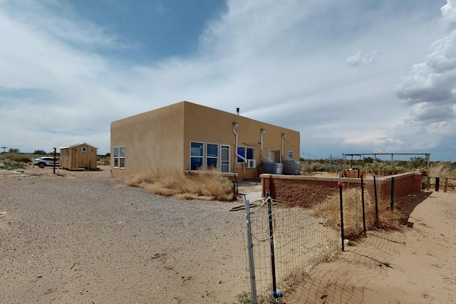 228 18th St SW, Rio Rancho, NM 87124 - view of home's exterior featuring stucco siding and a storage shed