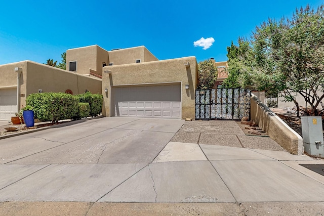 12800 Comanche Rd NE Unit 23, Albuquerque, NM 87111 - pueblo revival-style home with stucco siding, a garage, and concrete driveway