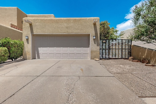 12800 Comanche Rd NE Unit 23, Albuquerque, NM 87111 - pueblo-style house featuring stucco siding, driveway, and an attached garage