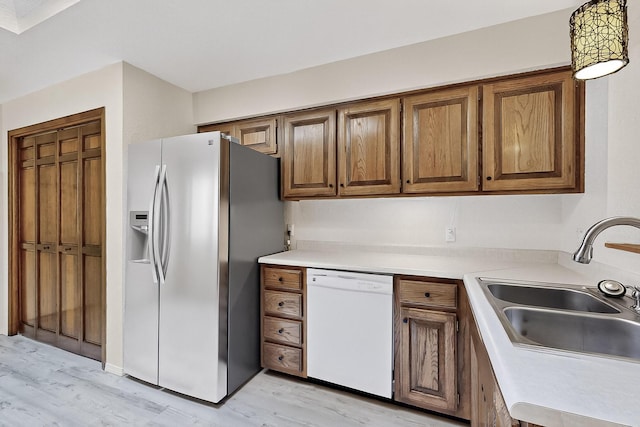 12800 Comanche Rd NE Unit 23, Albuquerque, NM 87111 - kitchen featuring white dishwasher, stainless steel fridge, light wood-type flooring, brown cabinetry, and light countertops