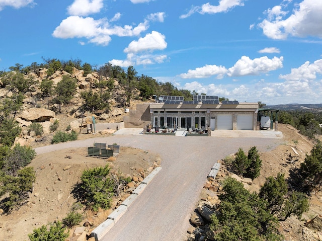 343 Webb Ranch Rd, Pie Town, NM 87827 - view of front facade with solar panels, an attached garage, and dirt driveway