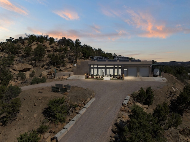 343 Webb Ranch Rd, Pie Town, NM 87827 - view of front of house featuring an attached garage, dirt driveway, and solar panels