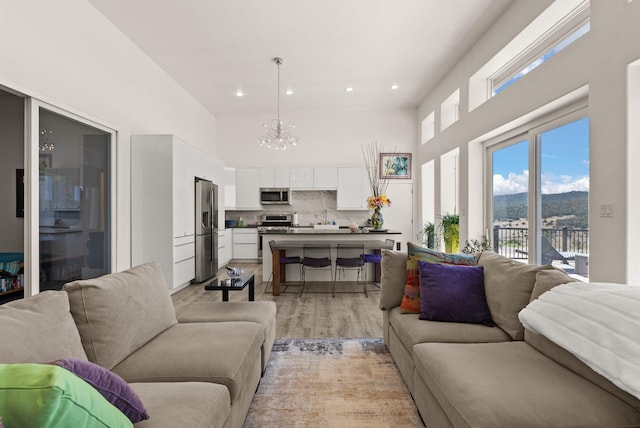 343 Webb Ranch Rd, Pie Town, NM 87827 - living room featuring a chandelier, a high ceiling, light wood-style floors, recessed lighting, and a mountain view