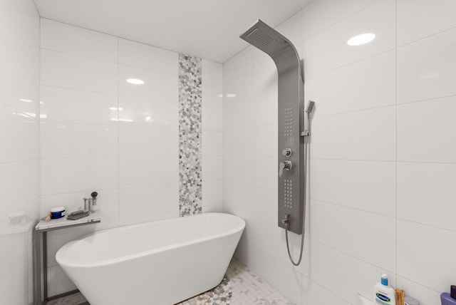 343 Webb Ranch Rd, Pie Town, NM 87827 - bathroom featuring tile walls, a freestanding tub, and tile patterned floors