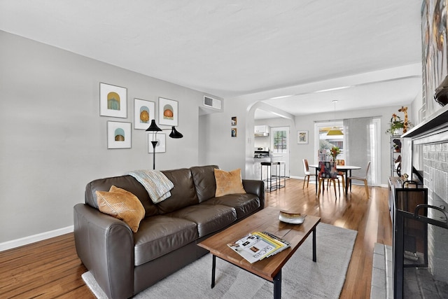 8206 Morrow Ave NE, Albuquerque, NM 87110 - living room with arched walkways and wood finished floors