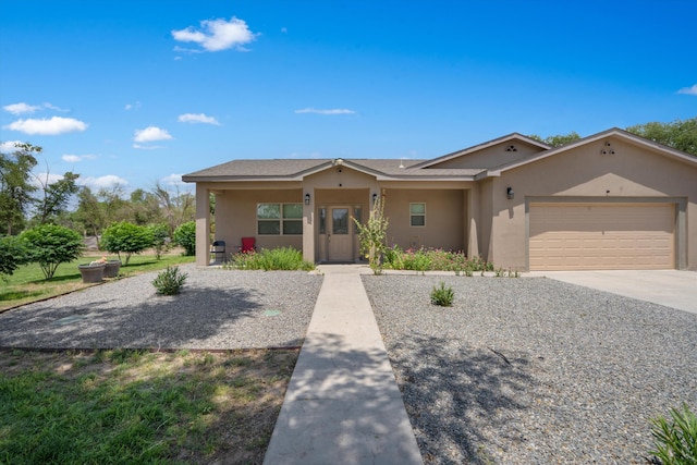 9 Elias Rd, Los Lunas, NM 87031 - view of front facade with stucco siding, a garage, and driveway