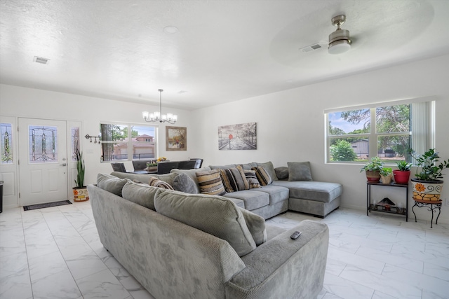 9 Elias Rd, Los Lunas, NM 87031 - living room with light marble finish flooring, a chandelier, healthy amount of natural light, and a ceiling fan