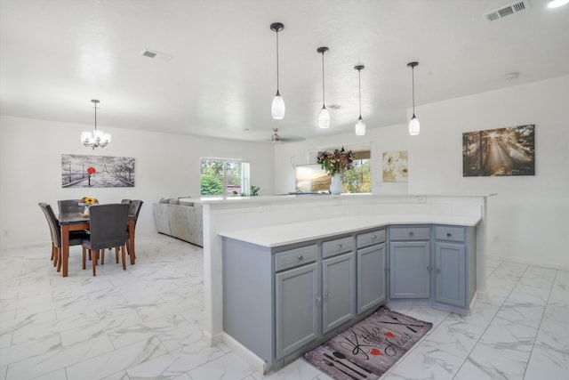 9 Elias Rd, Los Lunas, NM 87031 - kitchen featuring light marble finish flooring, a chandelier, gray cabinets, light countertops, and open floor plan