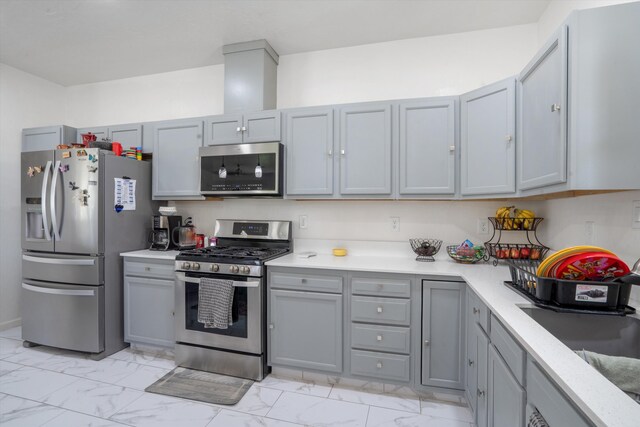 9 Elias Rd, Los Lunas, NM 87031 - kitchen with stainless steel appliances, light marble finish flooring, gray cabinets, and light countertops