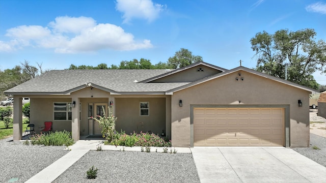 9 Elias Rd, Los Lunas, NM 87031 - view of front facade with stucco siding, a garage, concrete driveway, and roof with shingles