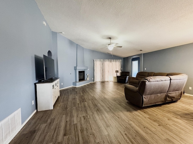 1543 White Pine Dr, Rio Rancho, NM 87144 - living area with wood finished floors, ceiling fan, a textured ceiling, lofted ceiling, and a glass covered fireplace
