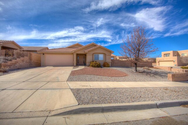 1543 White Pine Dr, Rio Rancho, NM 87144 - view of front of house with driveway, a tile roof, an attached garage, and stucco siding