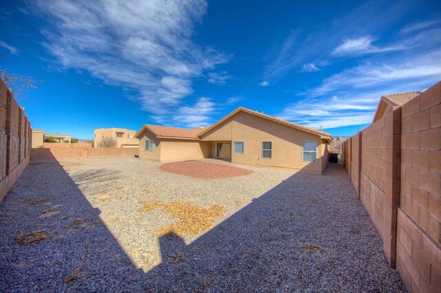 1543 White Pine Dr, Rio Rancho, NM 87144 - back of house with stucco siding and a fenced backyard
