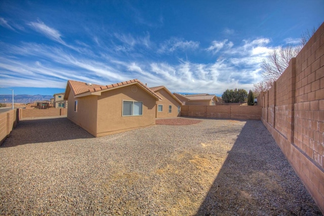 1543 White Pine Dr, Rio Rancho, NM 87144 - rear view of property featuring stucco siding, a fenced backyard, and a tiled roof