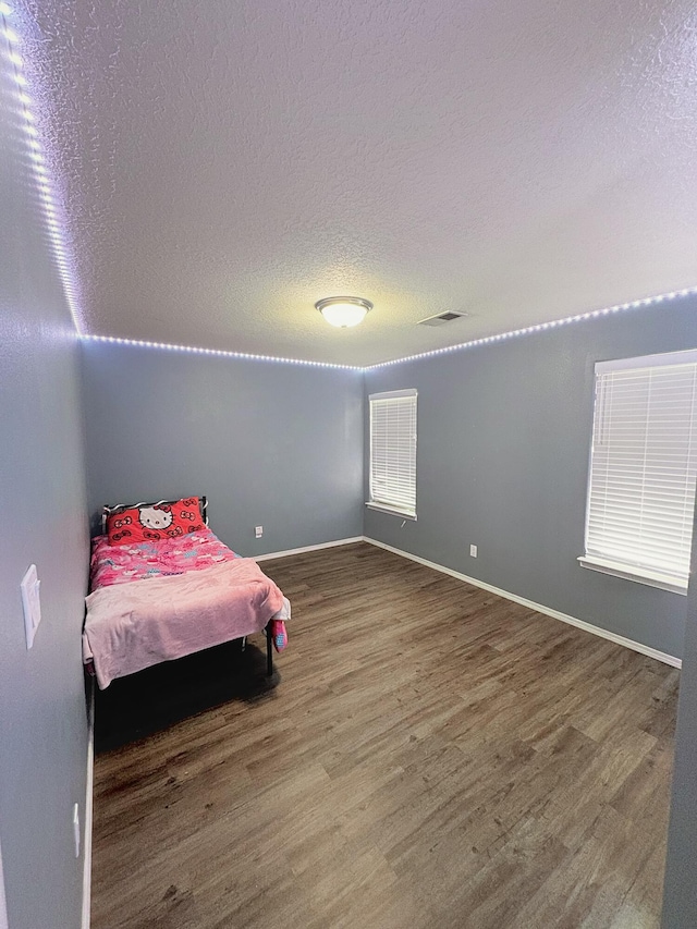1543 White Pine Dr, Rio Rancho, NM 87144 - bedroom featuring wood finished floors and a textured ceiling