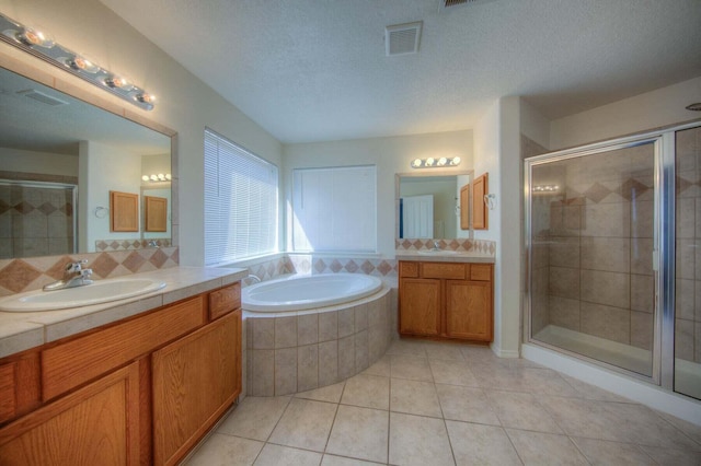 1543 White Pine Dr, Rio Rancho, NM 87144 - bathroom with a shower stall, tile patterned flooring, two vanities, a bath, and a textured ceiling