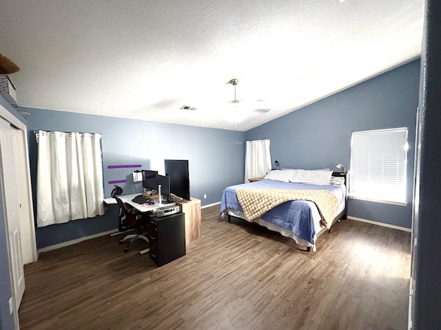 1543 White Pine Dr, Rio Rancho, NM 87144 - bedroom with wood finished floors, vaulted ceiling, a desk, and a textured ceiling