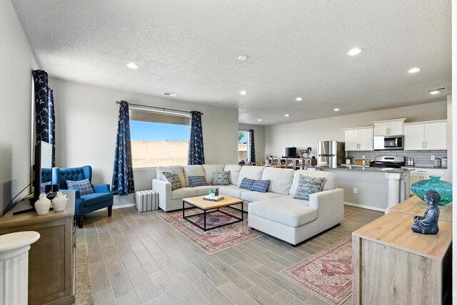 3209 Tazanita Loop SE, Rio Rancho, NM 87124 - living area with a textured ceiling, light wood-style flooring, and recessed lighting