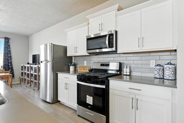 3209 Tazanita Loop SE, Rio Rancho, NM 87124 - kitchen with stainless steel appliances, tasteful backsplash, a textured ceiling, light wood-style floors, and white cabinets