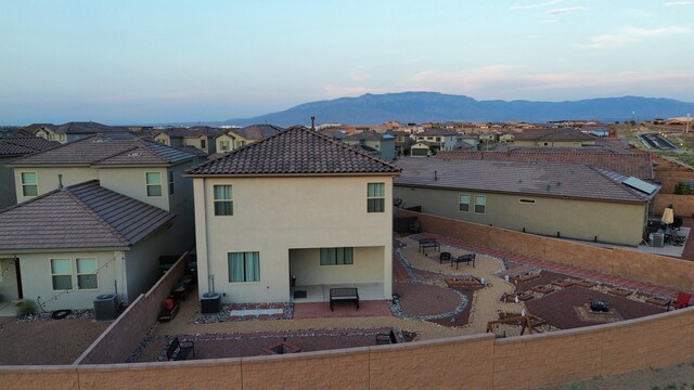 3209 Tazanita Loop SE, Rio Rancho, NM 87124 - rear view of house with a residential view, a mountain view, a patio area, a fenced backyard, and stucco siding