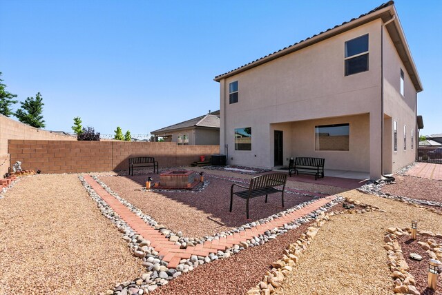 3209 Tazanita Loop SE, Rio Rancho, NM 87124 - back of property featuring a fire pit, stucco siding, a fenced backyard, and a patio