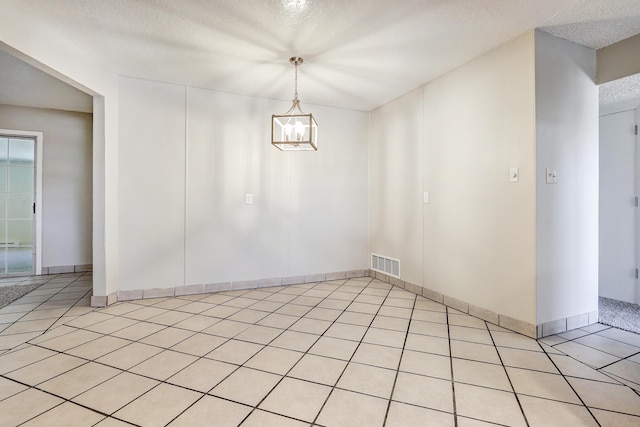 5711 Bohemio Ct SW, Albuquerque, NM 87105 - empty room with a textured ceiling, a chandelier, and light tile patterned floors