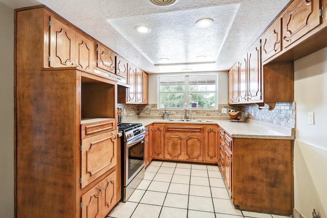5711 Bohemio Ct SW, Albuquerque, NM 87105 - kitchen featuring stainless steel range with gas cooktop, a textured ceiling, tasteful backsplash, light countertops, and light tile patterned floors