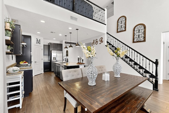 11805 Badger Mountain Trl NW, Albuquerque, NM 87120 - dining room with wood finished floors, stairway, recessed lighting, and a high ceiling