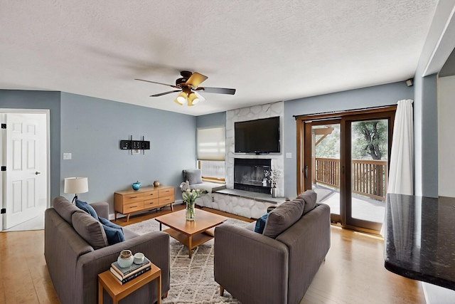 8 Fawn Rd, Cedar Crest, NM 87008 - living room with light wood finished floors, a textured ceiling, ceiling fan, and a premium fireplace