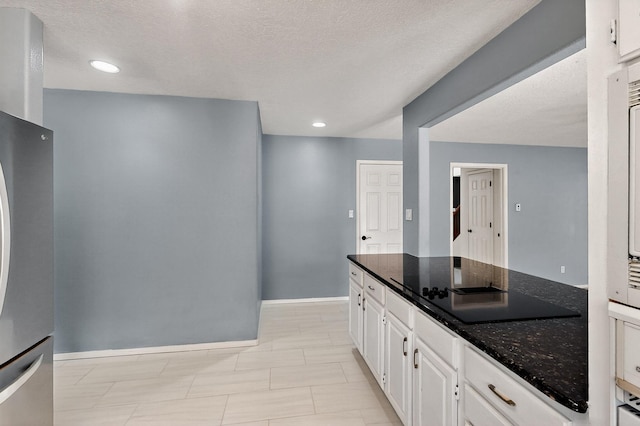 8 Fawn Rd, Cedar Crest, NM 87008 - kitchen with black electric cooktop, dark stone countertops, freestanding refrigerator, white cabinets, and a textured ceiling