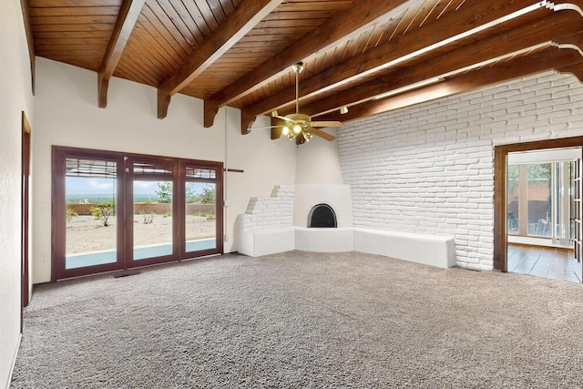 4904 Alberta Ln NW, Albuquerque, NM 87120 - unfurnished living room with carpet, a wood ceiling with exposed beams, ceiling fan, brick wall, and a fireplace