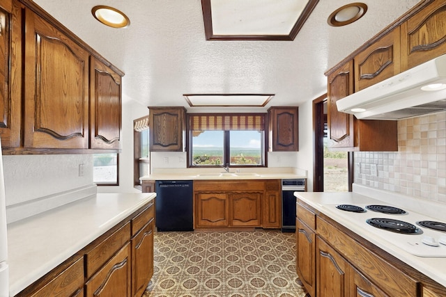 4904 Alberta Ln NW, Albuquerque, NM 87120 - kitchen with black dishwasher, white electric stovetop, under cabinet range hood, light countertops, and decorative backsplash