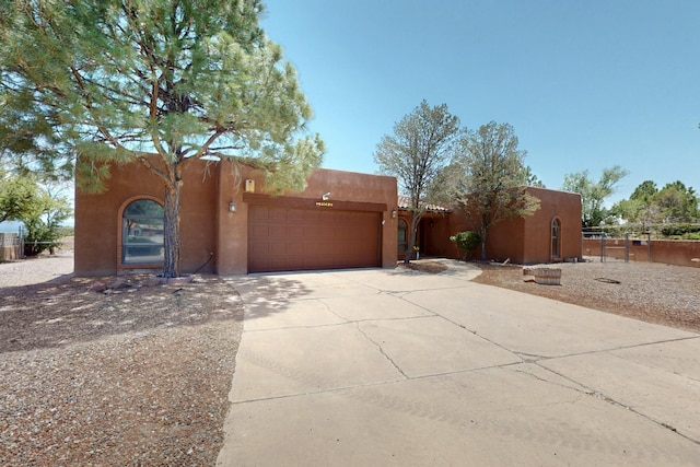 4904 Alberta Ln NW, Albuquerque, NM 87120 - pueblo revival-style home with driveway, stucco siding, and an attached garage