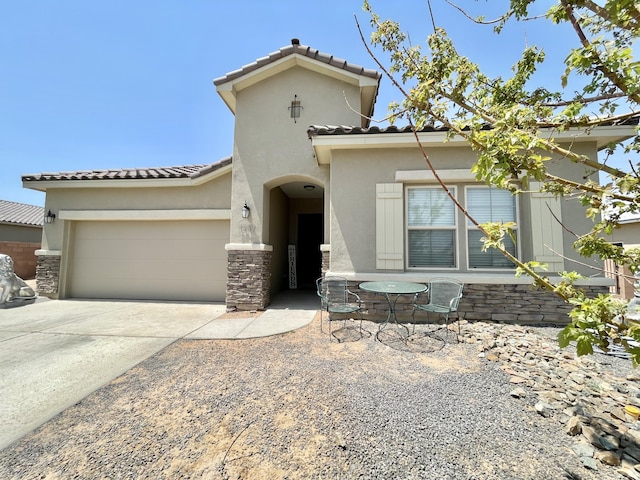 3237 Fennel Rd NE, Rio Rancho, NM 87144 - mediterranean / spanish house featuring a tiled roof, an attached garage, stucco siding, concrete driveway, and stone siding