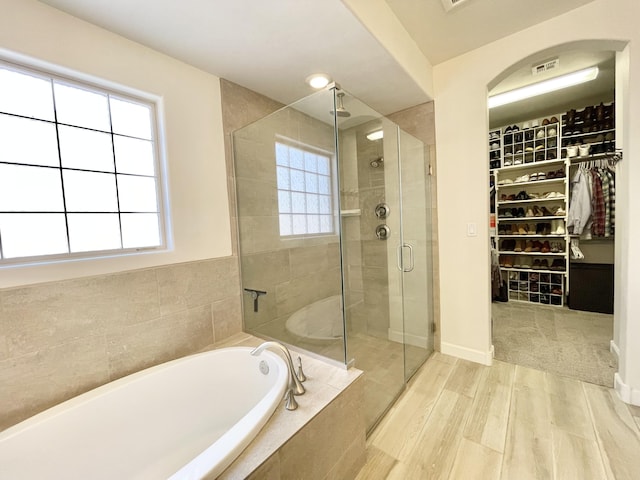 3237 Fennel Rd NE, Rio Rancho, NM 87144 - bathroom with a garden tub, a shower stall, a walk in closet, and wood finished floors