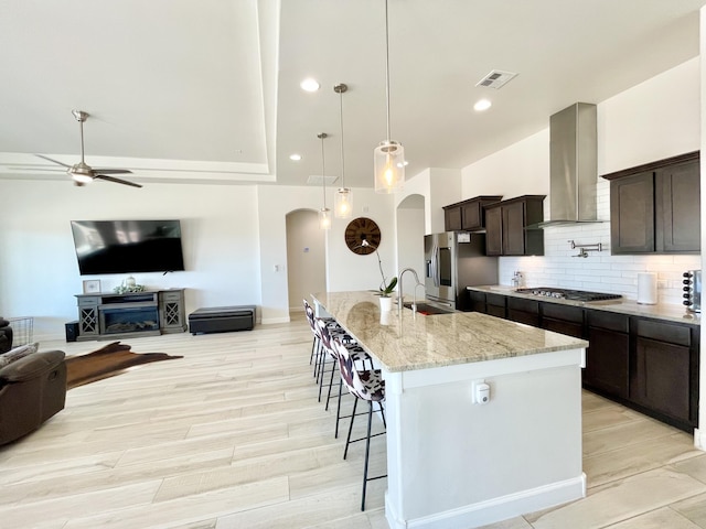 3237 Fennel Rd NE, Rio Rancho, NM 87144 - kitchen featuring stainless steel appliances, arched walkways, range hood, ceiling fan, and a breakfast bar