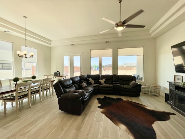 3237 Fennel Rd NE, Rio Rancho, NM 87144 - living area featuring a tray ceiling, a chandelier, light wood-style floors, and a ceiling fan