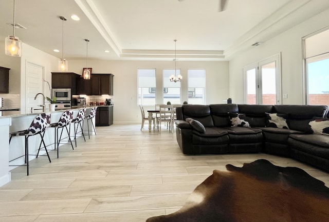 3237 Fennel Rd NE, Rio Rancho, NM 87144 - living area featuring a raised ceiling, a chandelier, light wood-type flooring, and recessed lighting