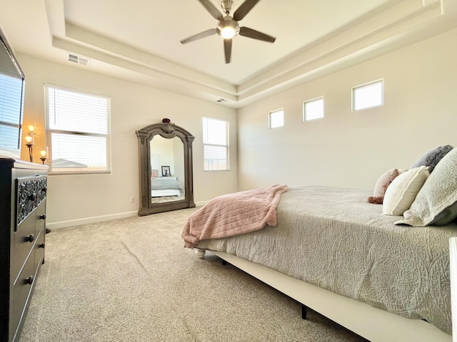 3237 Fennel Rd NE, Rio Rancho, NM 87144 - carpeted bedroom featuring a tray ceiling, multiple windows, and ceiling fan